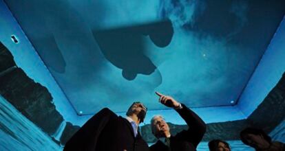 El presidente islandés, Olafur Ragnar Grimsson (d) y el ministro alemán de Asuntos Exteriores, Guido Westerwelle (i), observan una instalación audiovisual en el pabellón de Islandia, durante la inauguración de la Feria del Libro de Fráncfort.