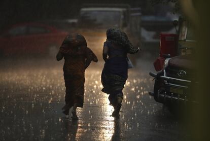Los peatones corren a refugiarse de una lluvia repentina en un día caluroso en Hyderabad, India, el lunes 3 de junio de 2019. Muchas partes de la India están experimentando condiciones de olas de calor con una temperatura de más de 45 grados centígrados.