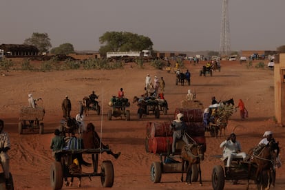 Grupos de pessoas transportam mercadorias a cavalo pela fronteira entre o Sudão e o Chade, em 25 de abril de 2024 em Adré, Chade.