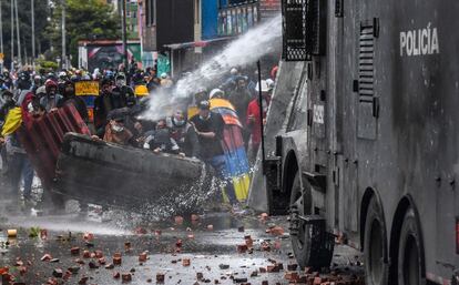 Varios manifestantes son dispersados mediante cañones de agua por la policía durante una protesta contra el presidente colombiano Iván Duque, en Bogotá, Colombia.