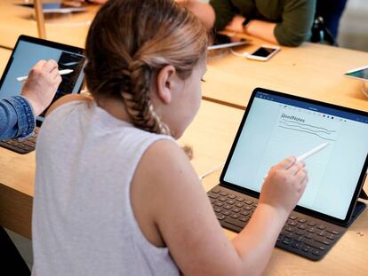 A girl uses an iPad at the grand opening of the new Apple Carnegie Library store in Washington