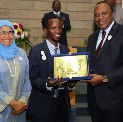 El presidente de Kenia, Uhuru Kenyatta, entrega a Kaka el diploma de honor de la ONU-Habitat por su labor inspirando a jóvenes en Mathare y en la coordinación del programa de recogida de residuos.  