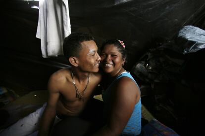 Los venezolanos Dajaira y Xavier sonríen dentro de la tienda de campaña en el campamento improvisado en el que se han asentado con un grupo de compatriotas en Quito (Ecuador).