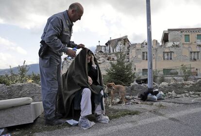 Uma idosa é auxiliada após o terremoto em Amatrice.