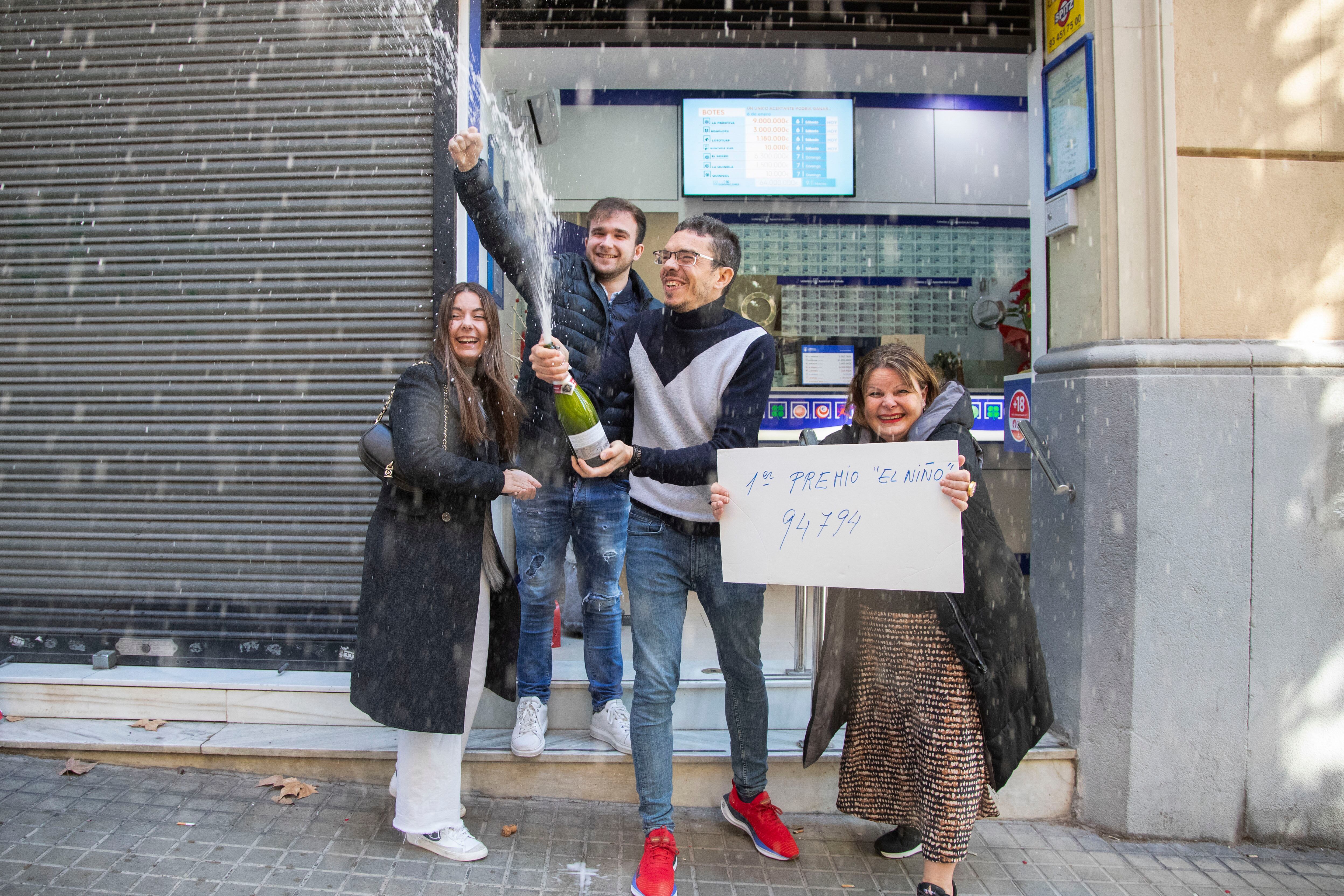 Oscar, el dueño de la administración número 287 de Barcelona, celebra con su familia haber vendido décimos del primer premio del sorteo extraordinario del Niño.