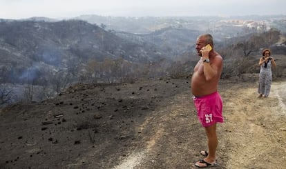 Varios vecinos de Coín contemplan el resultado del paso del fuego por la cercanía de sus casas.