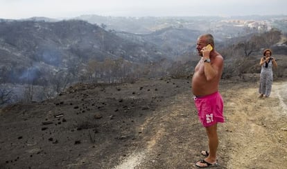 Varios vecinos de Co&iacute;n contemplan el resultado del paso del fuego por la cercan&iacute;a de sus casas. 