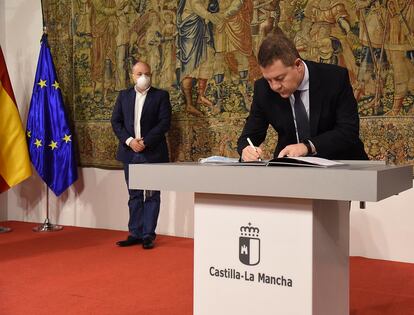 El presidente de Castilla-La Mancha, el socialista Emiliano García-Page, firma el acuerdo de reconstrucción en la comunidad. En la izquierda, Alejandro Ruiz, representante de Cs.