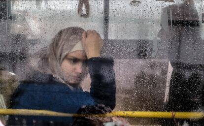 Una mujer siria mira a través de la ventana de un autobús que se prepara para abandonar Beirut y partir hacia Siria, este jueves en Burj Hammoud (Líbano). Un grupo de 1.300 refugiados sirios inician su regreso a casa desde diferentes zonas de Líbano, como parte de un plan coordinado por las autoridades de Beirut y Damasco.
