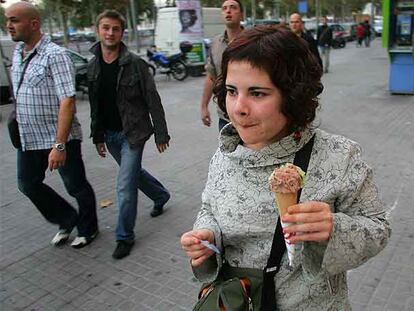 Una joven tomando un helado ayer en el barrio barcelonés de la Barceloneta.