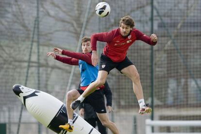 Llorente remata en el entrenamiento del Athletic ante la oposición de Amorebieta.