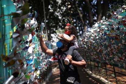 Pai e filha colocam um moinho de vento em homenagem às vítimas da covid-19, em São Paulo.