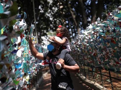 Pai e filha colocam um moinho de vento em homenagem às vítimas da covid-19, em São Paulo.
