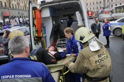 Una persona herida es atendida por los servicios de emergencia frente a la estación de metro de Sennaya Ploshchad, en San Petersburgo.