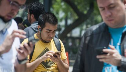 Un grupo de paseantes utiliza su celular en Ciudad de México. 