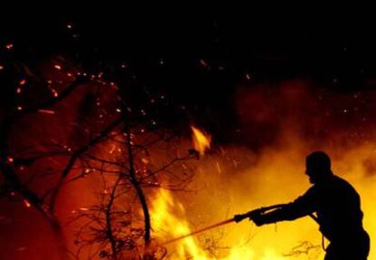 Un bombero intenta extinguir el fuego en el incendio de Cerdedo, en Pontevedra.