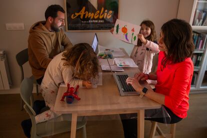 Adrián Cordellat, su mujer Diana Oliver y sus hijos Mara, 7, y Leo, 4, trabajan en el salón de su casa en Madrid.