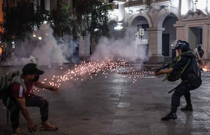 Un policía antidisturbios apunta a un manifestante, durante una protesta a favor de Pedro Castillo, en Lima (Perú), el 11 de diciembre de 2022.