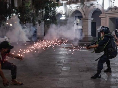 Un policía antidisturbios apunta a un manifestante, durante una protesta a favor de Pedro Castillo, en Lima (Perú), el 11 de diciembre de 2022.