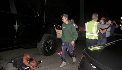 Justin Bieber pasa frente a su coche para comrobar el estado del fotógrafo herido.