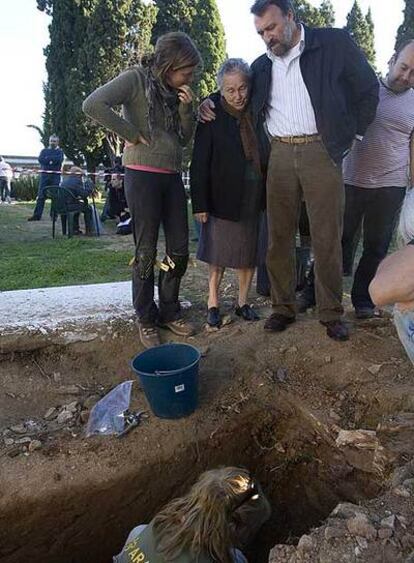 Antonia Trigo (centro) ante la fosa de su padre en Calañas, Huelva.