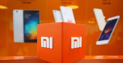 Logo de Xiaomi junto a móviles de la compañía en una oficina de la compañía en la India.