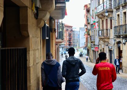 Tres jóvenes recorren el camino desde el albergue de la Cruz Roja de Irún hasta un punto de información para inmigrantes, en julio de 2021.
