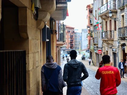 Tres jóvenes recorren el camino desde el albergue de la Cruz Roja de Irún hasta un punto de información para inmigrantes, en julio de 2021.