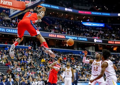 El escolta Bradley Beal (izquierda), de Washington Wizards, se cuelga de la cesta durante un partido de baloncesto de la NBA entre Washington Wizards y Cleveland Cavaliers , en el Capital One Arena de Washington, DC (Estados Unidos).