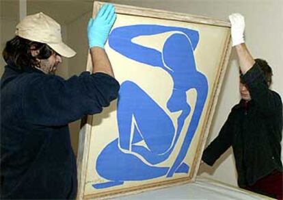Dos operarios colocan <i> Desnudo azul IV</i> (1952), de Henri Matisse, en la Galería de Arte Moderno de Bolonia.