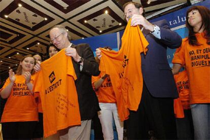 Josep Piqué y Mariano Rajoy, muestran las camisetas contra el Estatuto, junto a un grupo de simpatizantes, en Lleida.