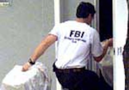 Un miembro del FBI saca pruebas tras el registro de un domicilio en Boca Ratón.