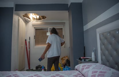 Fina muestra el agujero que sus vecinos hicieron en el techo de su habitación para rescatarla a ella y a su familia el día de la dana en El Raval de Algemesí. 
