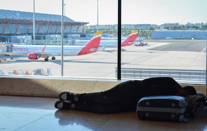 Una persona descansa en el Aeropuerto de Madrid Barajas, en una imagen de archivo.