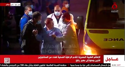 Rehenes de Hamás se bajan de la ambulancia con la que han atravesado el cruce fronterizo con Gaza, este viernes.  l