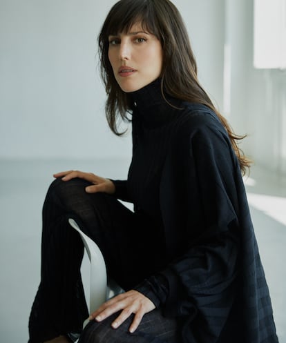 Natalia de Molina lleva conjunto de punto semitransparente con jersey de cuello alto, pantalón largo y chaqueta tipo quimono, todo de DIOR.