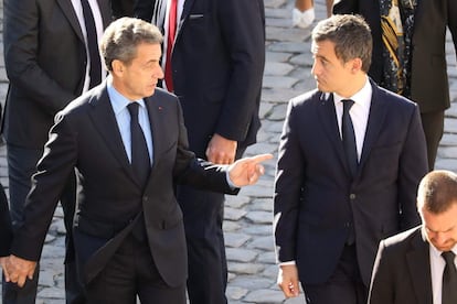 El expresidente francés Nicolas Sarkozy y el ministro Gerald Darmanin, conversan durante el homenaje al cantautor francés.