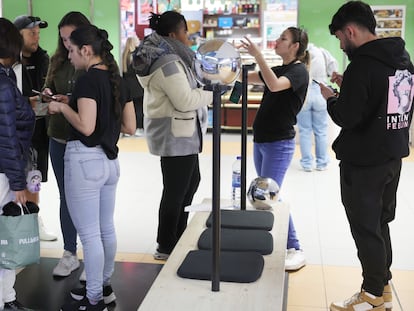 Colas para fotografiarse el iris para registrarse en Worldcoin en el pequeño puesto del Intercambiador de Avenida de América (Madrid)..