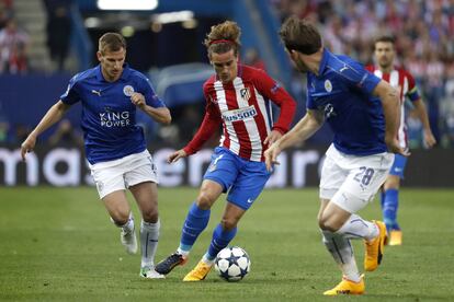 El delantero del Atlético Antoine Griezmann (c) con el balón junto a los jugadores del Leicester Marc Albrighton y Christian Fuchs.