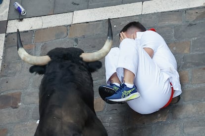 Un mozo se protege tras caer al paso de los astados, este jueves.