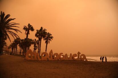 Así se ve el cielo anaranjado que deja la calima desde la playa de La Malagueta, en Málaga.