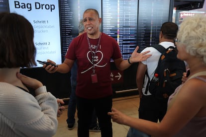 Derek Bangura, empleado del aeropuerto de Berlín, atiendo a los viajeros durante el apagón informático, este viernes