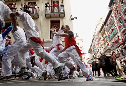 Toros de la ganadería Garcigrande corre tras los mozos en la curva de la calle Estafeta.