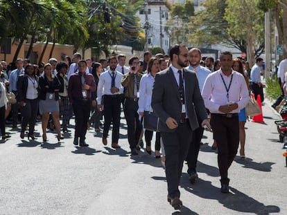 Decenas de trabajadores salen a la calle en Santo Domingo ante el sismo, este lunes.