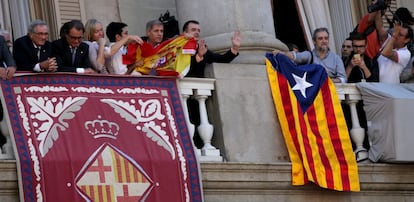 Alberto Fernández Díaz intenta penjar la bandera espanyola, mentre Gerardo Pisarello l'estira per evitar-ho.