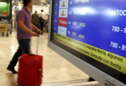 Un hombre pasa en la T-4 del Aeropuerto de Madrid-Barajas por delante de una pantalla informativa en la que se informa de la huelga de los tripulantes de la compañía Iberia. EFE/Archivo