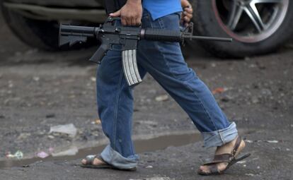 Un hombre del Consejo de Autodefensa de Michoacán, (CAM), lleva su arma a un puesto de Antunez, México. Los vigilantes del estado de Michoacán, insisten en no deponer las armas hasta que se no se detenga a los principales líderes de un poderoso cartel de la droga.