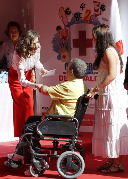 La reina conversa con una de las personas que ha contribuido con la organización que este año dedica la recaudación a la lucha contra la pobreza infantil. 