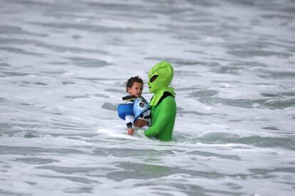 Un niño disfrazado de astronauta y su padre, disfrazado de alien, en el concurso anual de surf de Halloween en Santa Monica, California (EE.UU).  