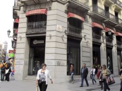Varios peatones caminan frente una tienda en la calle madrileña de Preciados. EFE/Archivo